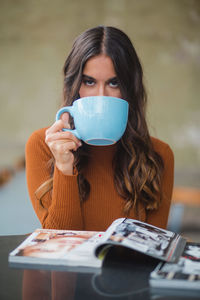 Portrait of a beautiful young woman drinking glasses