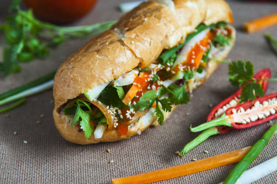 Close-up of sandwich and vegetables on table