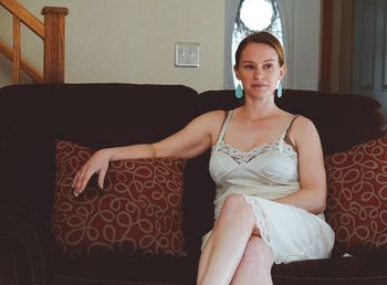 Young woman sitting on sofa at home