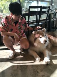 Full length of woman sitting with dog