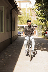 Full length of woman riding bicycle on street