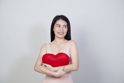 Portrait of a smiling young woman against white background