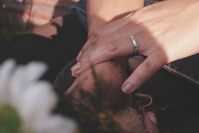 Cropped hands of woman holding flower