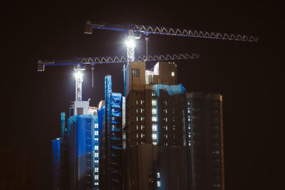 Low angle view of illuminated buildings in city at night