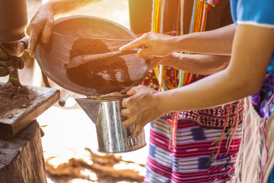 Midsection of women preparing food in kitchen