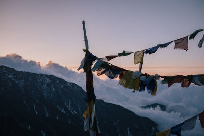 Clothes drying on snow covered mountain against sky