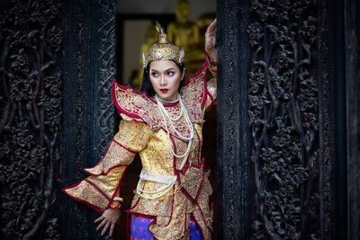 Woman in traditional dress standing at buddhist temple