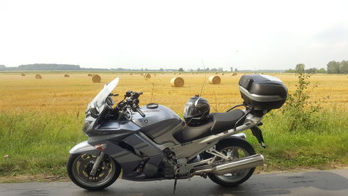 Motorcycle on field against sky