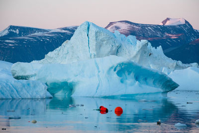 Scenic view of ice floating on sea against sky