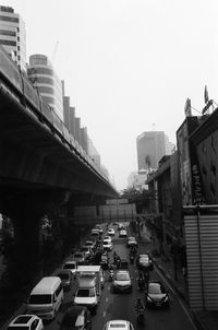 Traffic on road in city against clear sky