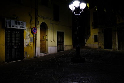 Street amidst buildings in city at night