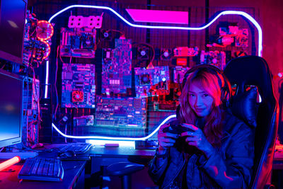 Portrait of young woman using mobile phone in factory