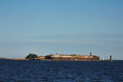 Sea by city against sky