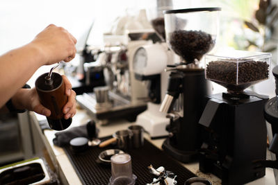 Banner of asian barista tamping the portafilter and preparing cup of coffee