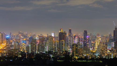 Aerial view of illuminated buildings in city against sky