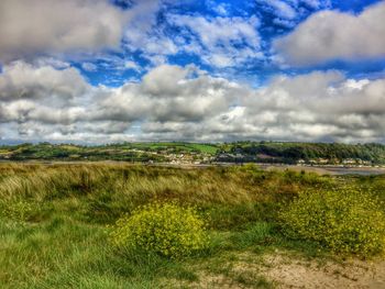 Scenic view of field against cloudy sky