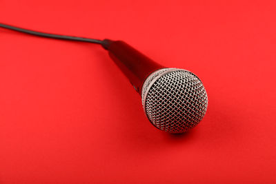 Close-up of microphone on red background