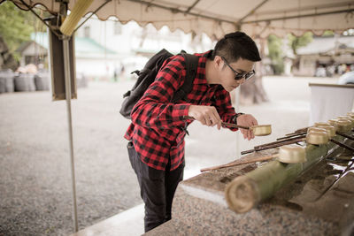 Man pouring water with ladle on hand