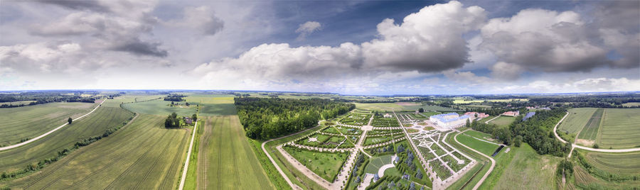 Panoramic view of road amidst field against sky