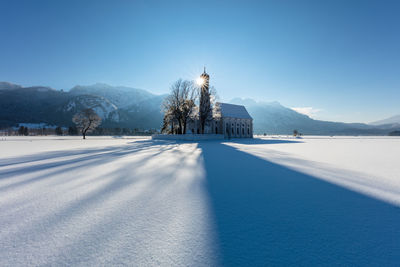 Scenic view of snow covered mountains against clear blue sky