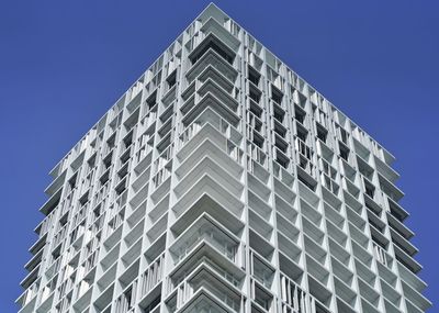 Low angle view of modern building against clear blue sky