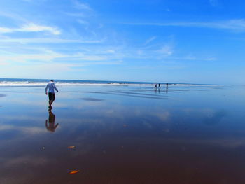 Rear view of man in sea against sky