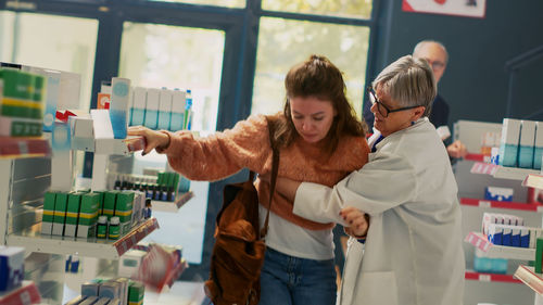 Side view of female friends standing in laboratory