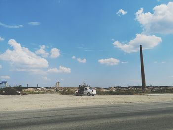 Cars on road against sky in city