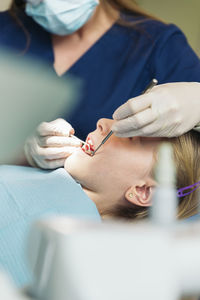 Female dentist examining girl at clinic