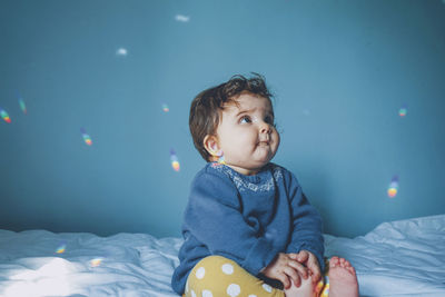 Cute baby girl on bed at home