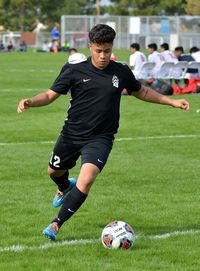 Young man playing soccer on field