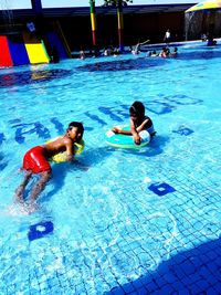 High angle view of friends swimming in pool