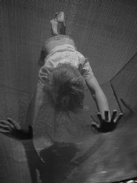 Low angle view of playful boy performing handstand on trampoline