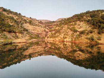 Reflection of mountain in lake against clear sky