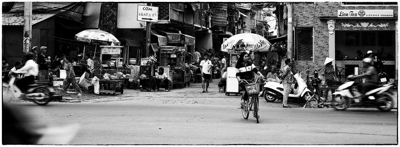 transportation, men, auto post production filter, person, bicycle, lifestyles, mode of transport, full length, transfer print, land vehicle, road, side view, leisure activity, on the move, city, consumerism, store, retail, street, architecture, casual clothing, city life, shopping, retail display, day