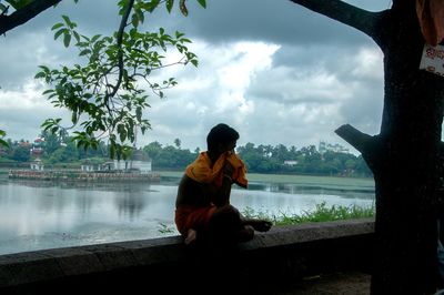 Woman sitting on tree trunk