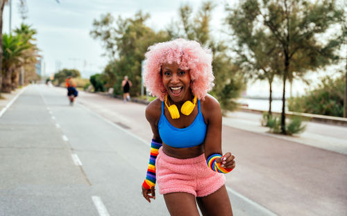 Portrait of young woman standing on road