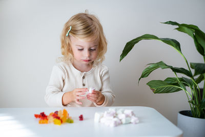 Portrait of cute girl sitting on table at home