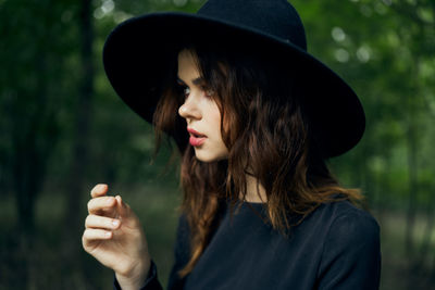 Portrait of young woman wearing hat standing outdoors