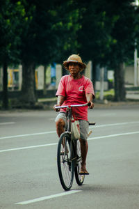 Portrait of man riding bicycle on road