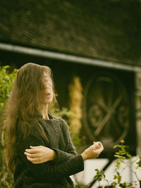 Woman in romantic pose between rustic houses, slovenia ii