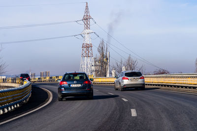 Cars on road against sky in city