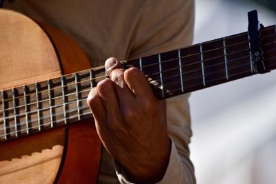 Midsection of man playing guitar