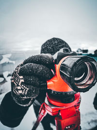 Close-up of person photographing at snow field