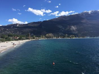 Scenic view of sea and mountains against sky