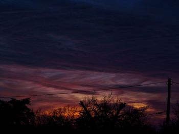 Low angle view of silhouette trees against sky at sunset