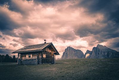 House on field against sky during sunset