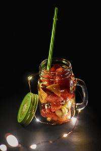 Close-up of drink in glass jar on table against black background