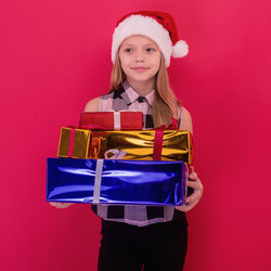 Portrait of a smiling young woman against red background