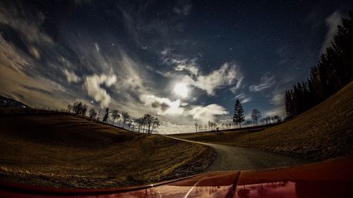 Road by landscape against sky at night